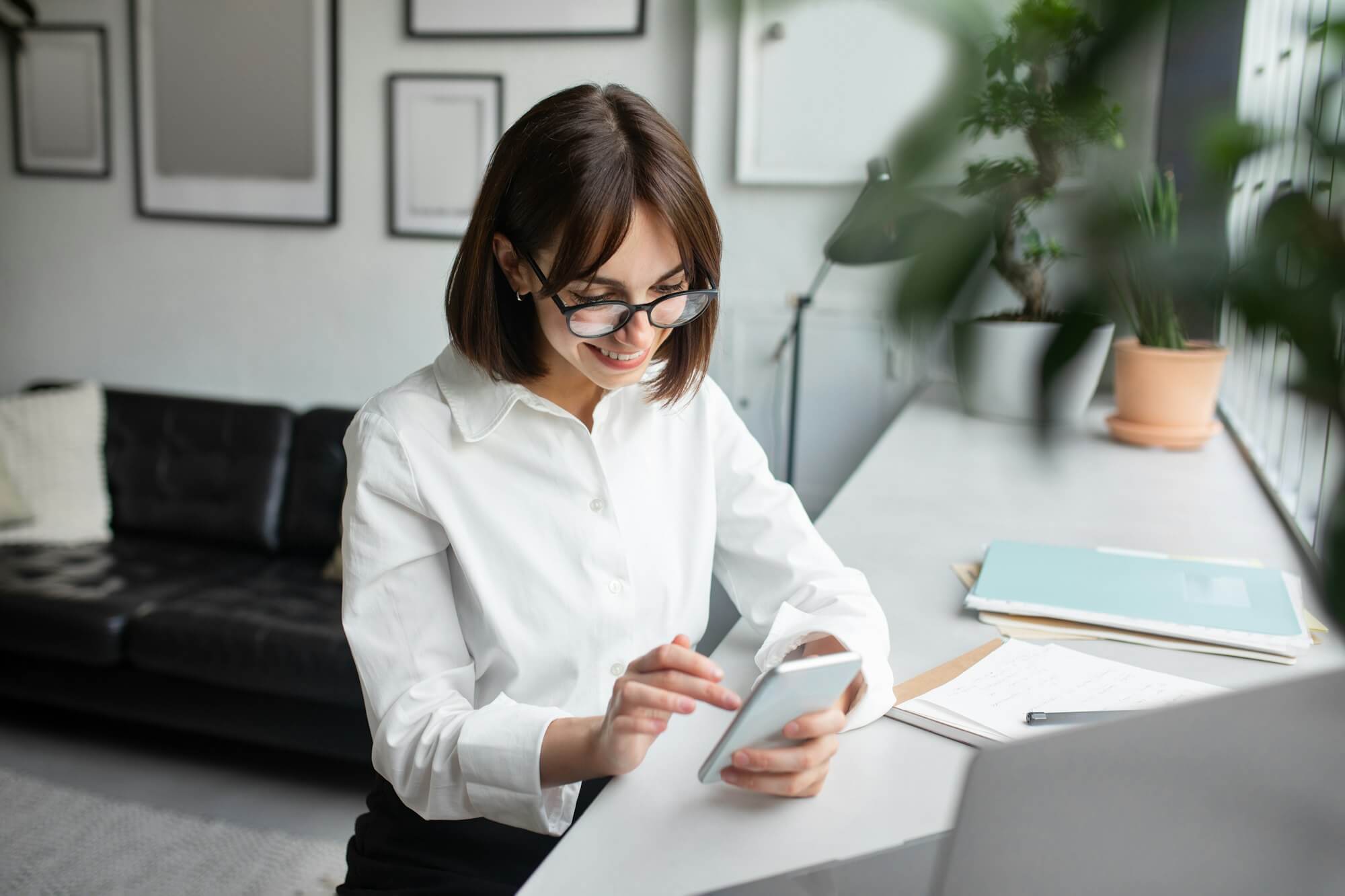 young-female-employee-using-cellphone-at-workplace-in-office-or-coworking-space-enjoying-break-at.jpg